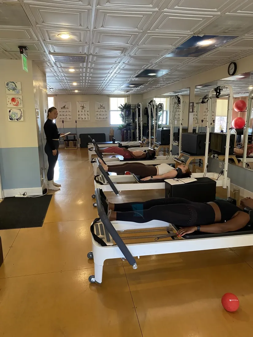 A group reformer class seen from the back of the studio